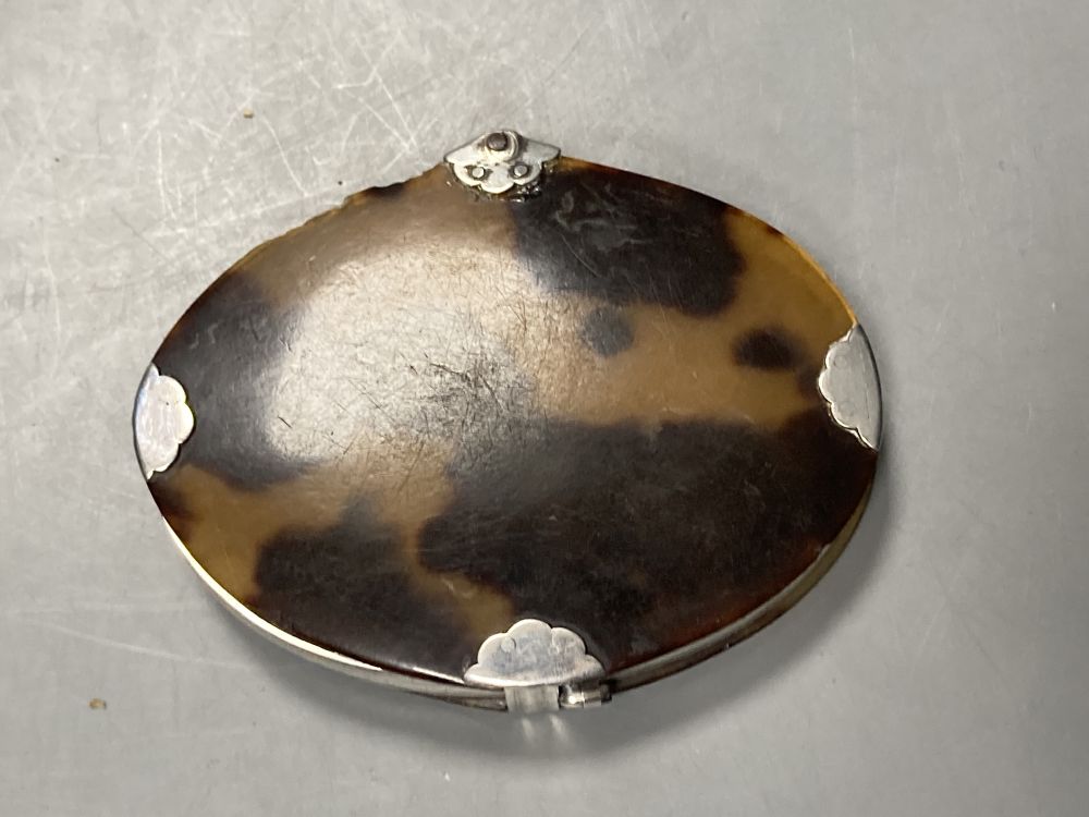 A Georgian tortoiseshell and white metal mounted oval magnifying glass, 86mm(a.f.).